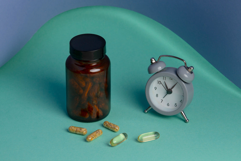 A bottle of pills with a clock, indicating when to take Tongkat Ali for energy and performance.