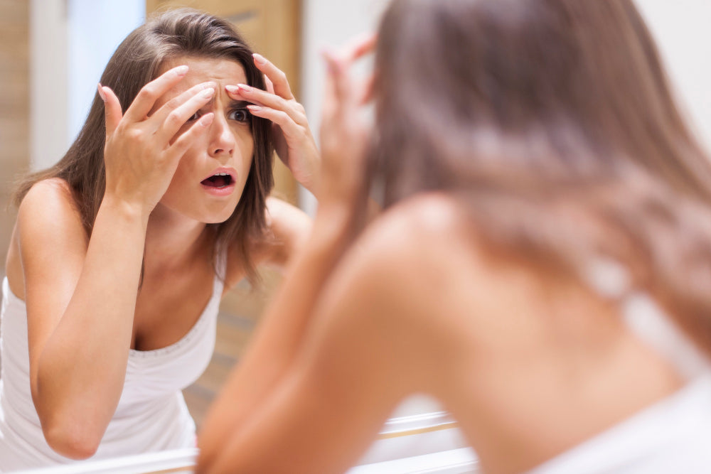 Woman is looking her skin onto the mirror