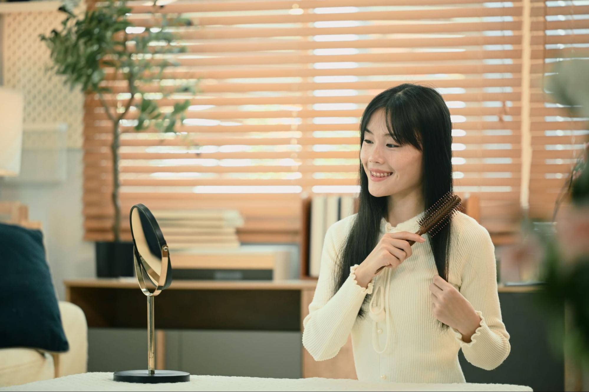 Woman brushing healthy dark hair for hair supplement guide